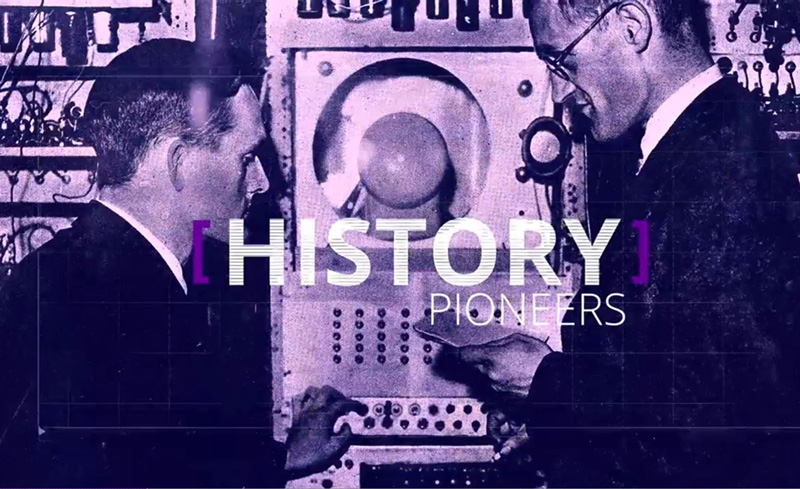 Two men stood in front of an old computer