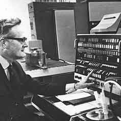 Black and white photo of man operating an old switchboard