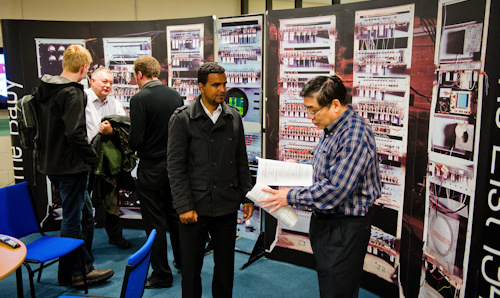 Older man talking to younger man in front of a display