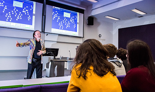 Male lecturer giving a lecture to a group of undergradautes